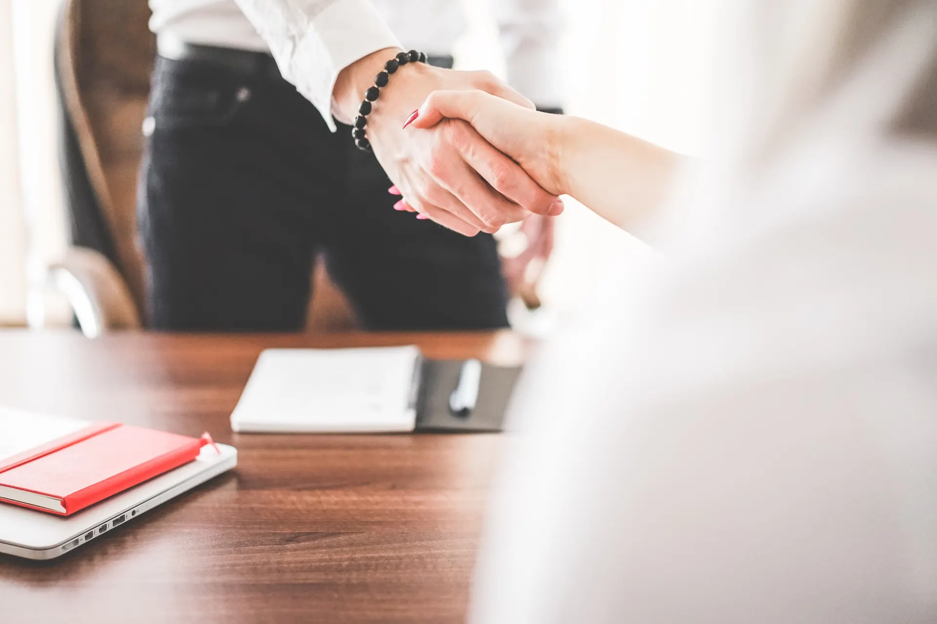 Business handshake across a desk